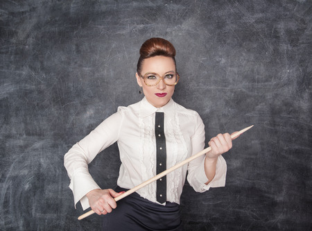 27085027 - strict teacher with wooden pointer looking at someone
